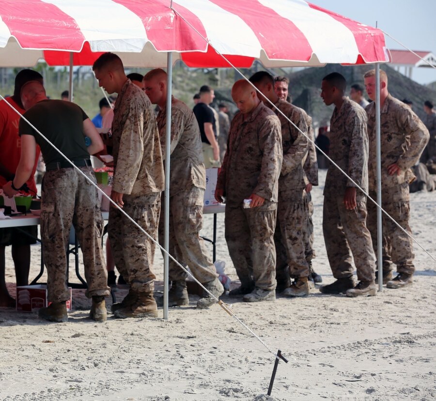 Marines from 2nd Battalion, 2nd Marine Regiment, 2nd Marine Division enjoy hot food and cold drinks after the battalion's Endurance Event June 20 at Camp Lejeune, N.C. The battalion had a Family Day set up for the Marines as soon as they crossed the finish line. (U.S. Marine Corps Photo by Lance Cpl. Ryan Young/released)


