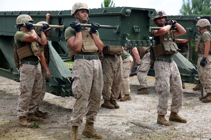 Marines with 8th Engineer Support Battalion, 2nd Marine Logistics Group work with personnel from 9th Engineer Support Battalion, 3rd Marine Logistics Group to lift and disconnect a panel of the medium girder bridge during bridge assembly training at Camp Lejeune, N.C. Aug. 5, 2014. Together they built a 22-bay, double-story bridge with link reinforcement. (U.S. Marine Corps photo by Lance Cpl. Kaitlyn Klein/released)


