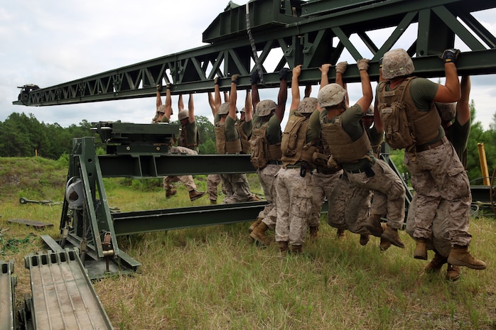 Marines with 8th Engineer Support Battalion, 2nd Marine Logistics Group work with personnel from 9th Engineer Support Battalion, 3rd Marine Logistics Group to pull down on the nose of the medium girder bridge as they lock everything in place during bridge assembly training at Camp Lejeune, N.C. Aug. 5, 2014. This training maintained gap-crossing capabilities and developed proficiency in bridging. (U.S. Marine Corps photo by Lance Cpl. Kaitlyn Klein/released)


