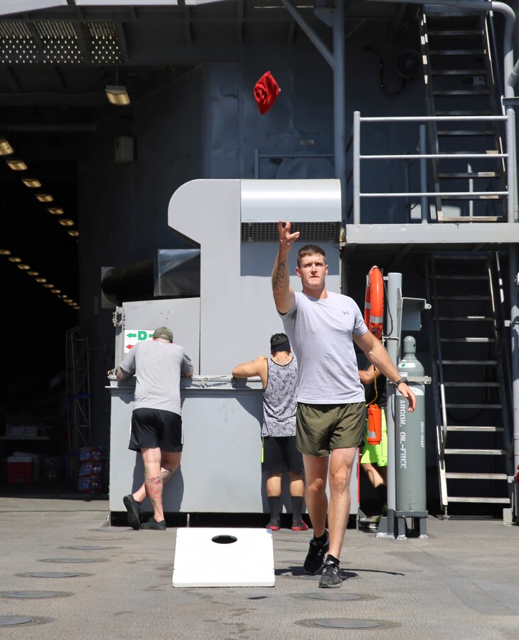 Sergeant Joe Campbell, a calibration technician with 2nd Maintenance Battalion, Combat Logistics Regiment 25, Marine Corps Base Camp Lejeune, N.C., throws a bean bag for a game of corn hole during a steel beach barbeque aboard the USS Oak Hill, June 29. The steel beach acted as a way for the Marines and sailors to build camaraderie, thus aiding in effective mission accomplishment before arriving in Boston for the Fourth of July Harborfest, July 1-7. (U.S. Marine Corps photo by Lance Cpl. Krista James)


