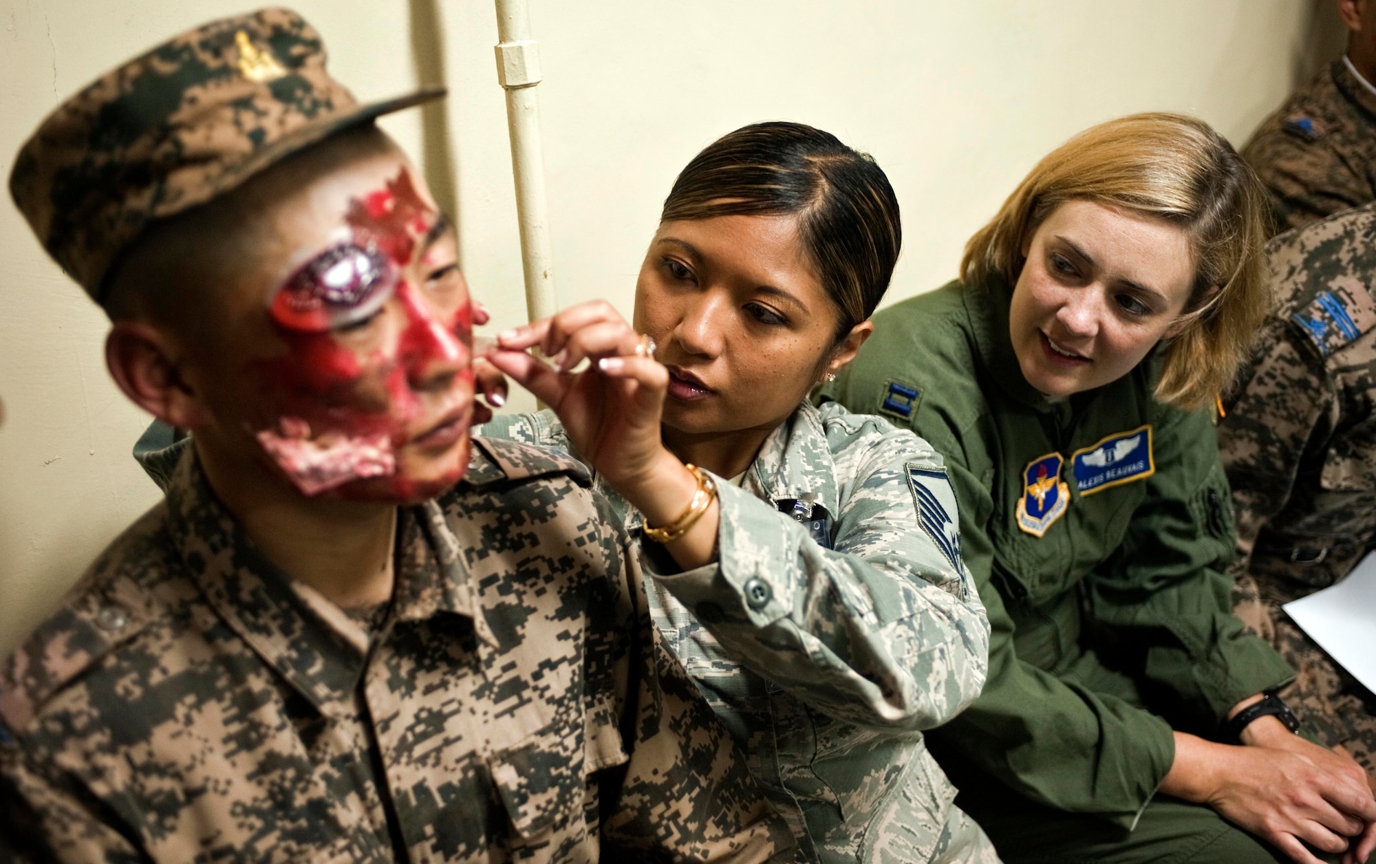 U.S. Air Force Master Sgt. Victoria Grey, middle, and Capt. Alexis Beauvais moulage a member of the Mongolian armed forces as part of mass casualty response training during Operation Pacific Angel 14-4 Mongolia, Aug. 8 2014, in Ulaanbaatar, Mongolia. Operation PACANGEL helps cultivate common bonds and fosters goodwill between the U.S., Mongolia and regional nations by conducting multilateral humanitarian assistance and civil military operations. Grey and Beauvais are medical subject matter expert instructors. (U.S. Air Force photo/Staff Sgt. William Banton)