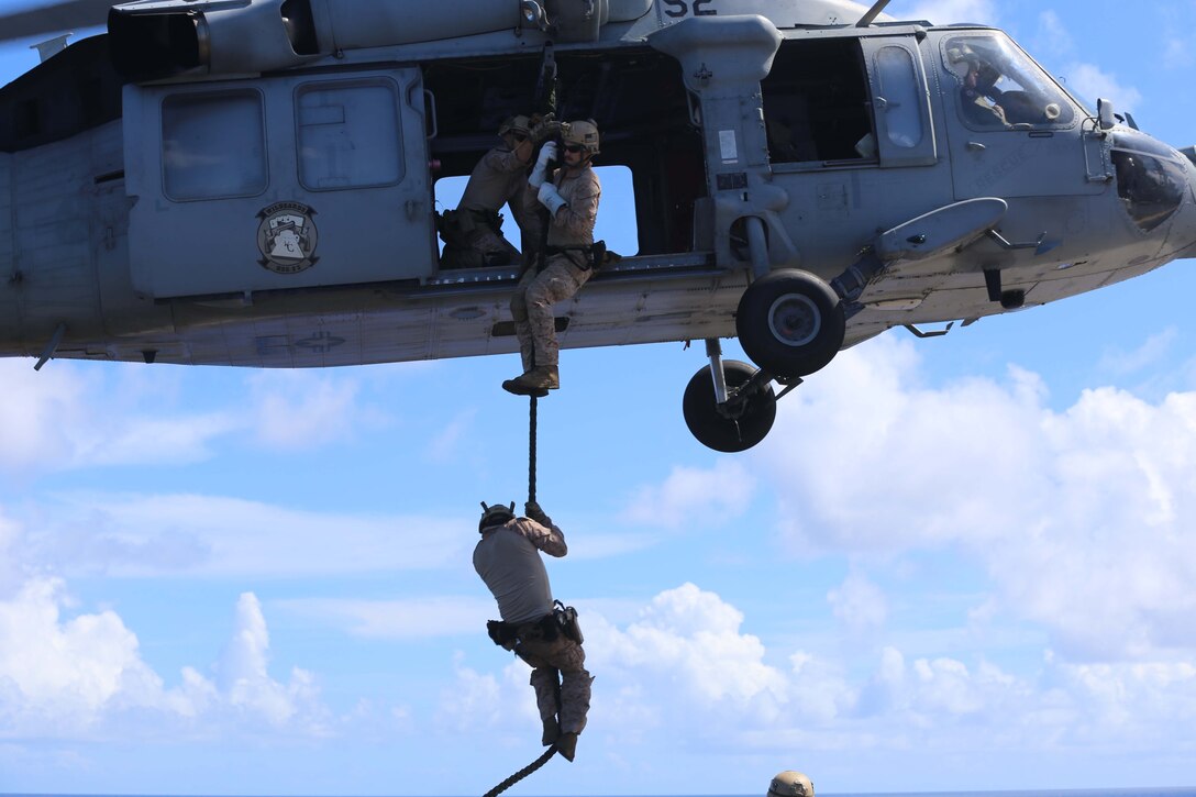 Marines with the reconnaissance detachment, 11th Marine Expeditionary Unit, conduct a modified fast-rope training exercise as part of the MEU's WESTPAC 14-2 deployment aboard the USS Makin Island Aug. 14, 2014. The 11th MEU and Makin Island Amphibious Ready Group are deployed to the 7th Fleet area of operations as a sea based, expeditionary crisis response force capable of conducting amphibious missions across the full range of military operations. (U.S. Marine Corps photo by Cpl. Demetrius Morgan/RELEASED)      