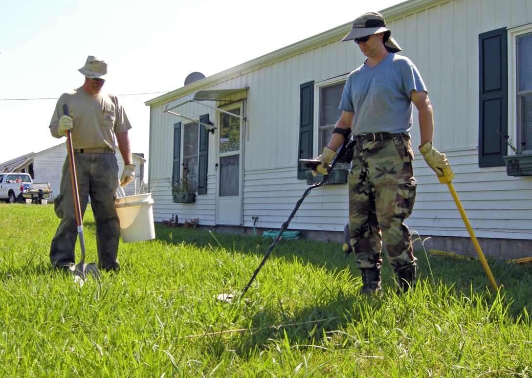 Contractors search for unexploded ordnance (UXO) and other debris near a mobile home that's located on the former Camp Butner training area near Butner, North Carolina. The Formerly Used Defense Site (FUDS) was a World War II infantry training installation hastily built in 1942. The once rural area north of Raleigh is becoming suburban sprawl, and before homes are built the land must be first cleared with the owner's permission. For more information about the FUDS program go to the following link;  http://www.usace.army.mil/Missions/Environmental/FormerlyUsedDefenseSites.aspx