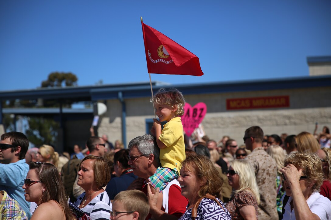 A child holds a Marine Corps flag while waiting for Marines with Marine Heavy Helicopter Squadron (HMH) 466 to arrive during a homecoming event aboard Marine Corps Air Station Miramar, Calif., Aug. 15. HMH-466 recently returned from a deployment, and were greeted at their homecoming by family and friends. 