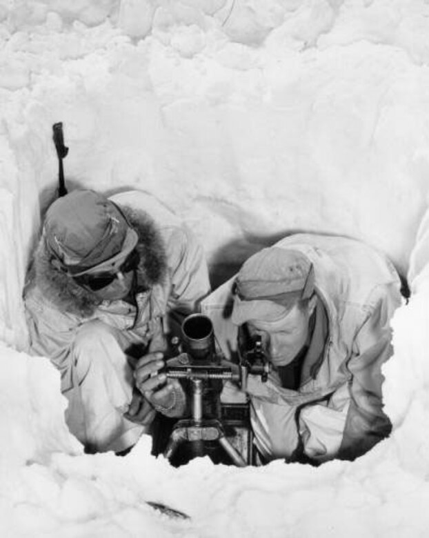 PFC Thomas Boulson and PFC Howard McDowell, huddle in a hole in the snow as McDowell sights a 60 mm mortar. The men fired practice rounds while on maneuvers at Resolution Mountain in Eagle County, Colo., in April 1944. Photo part of the Western History Collection at the Denver Public Library.
