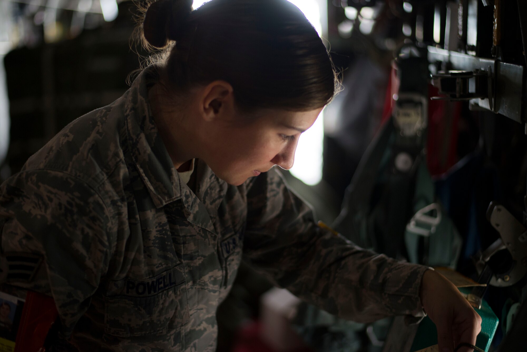 Senior Airman Katie Powell, 374th Operations Support Squadron aircrew flight equipment specialist, inspects personnel parachutes on a C-130 Hercules prior to take off during Exercise RED FLAG-Alaska on Aug. 5, 2014 at Joint Base Elmendorf-Richardson, Alaska. AFE specialists are tasked to inspect oxygen masks and parachutes before every flight. (U.S. Air Force photo by Staff Sgt. Chad C. Strohmeyer/Released)
