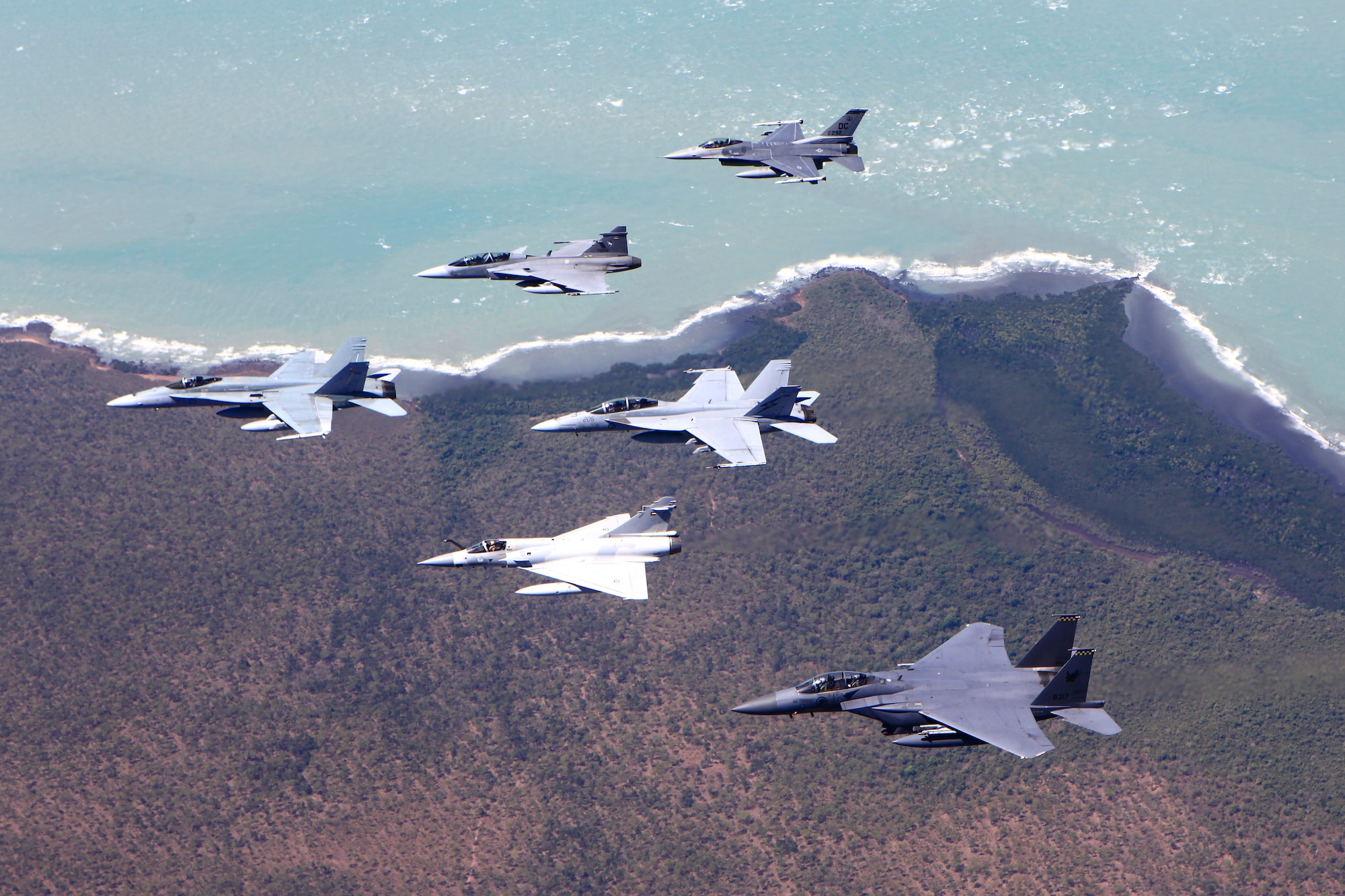 An F-16 Fighting Falcon aircraft from the D.C. Air National Guard performs an air-to-air formation with aircraft from the Royal Thai, United Arab Emirates, Republic of Singapore and Royal Australian air forces during Pitch Black 2014. The ANG unit is deployed to Australia from Kunsan Air Base, Republic of Korea. Pitch Black is the RAAF’s largest and most complex air exercise, traditionally held in the Northern Territory every two years. Exercise Pitch Black is being conducted from RAAF Bases Darwin and Tindal Aug. 1 through 22, 2014, featuring participants from Australia, the United States, New Zealand, Singapore, Thailand, United Arab Emirates and French Air Force (New Caledonia) who will cooperate for Offensive Counter Air (OCA) and Defensive Counter Air (DCA) missions. (Royal Australian Air Force photo by Cpl. David Gibbs/Released)
