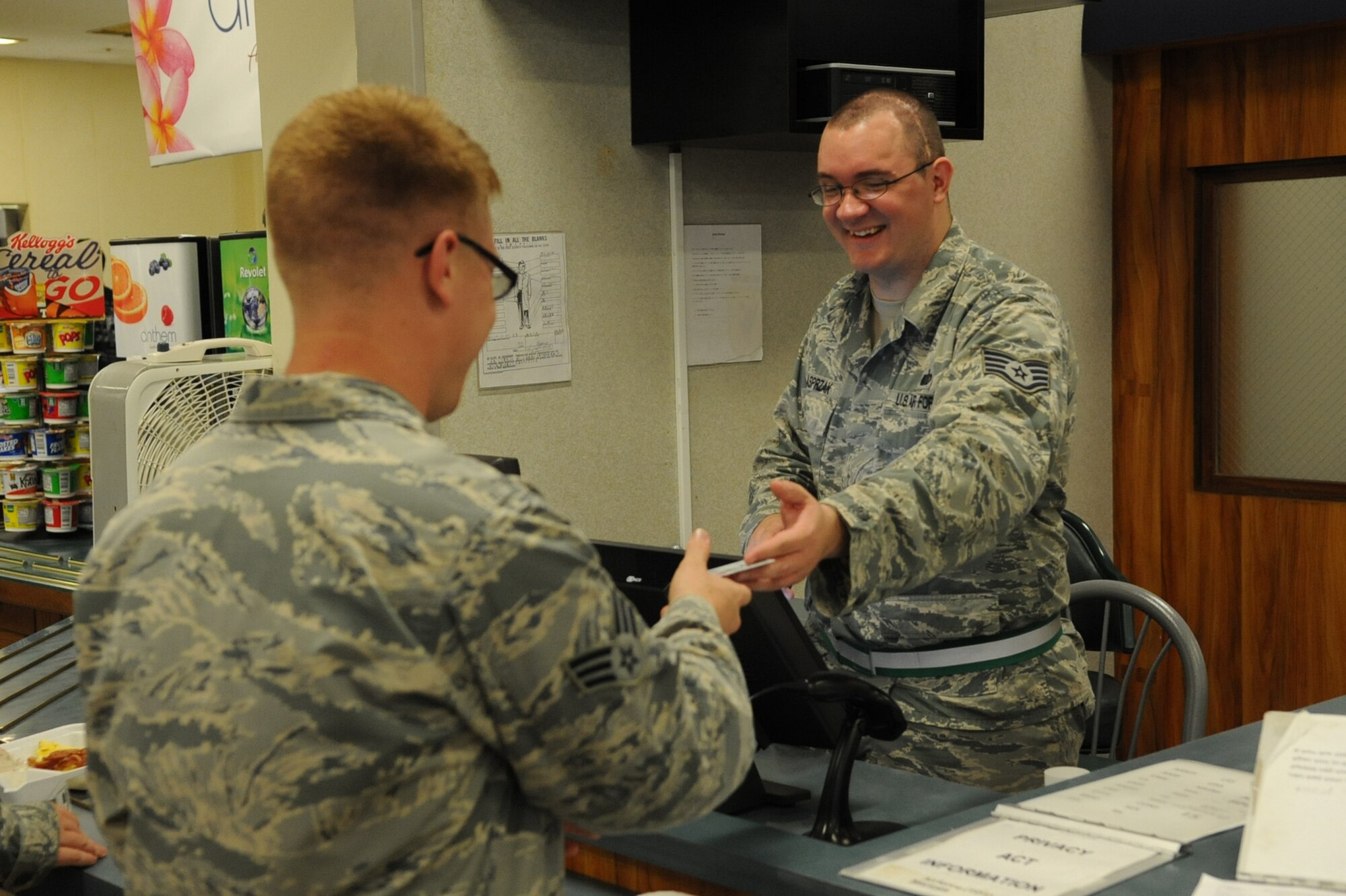 U.S. Air Force Staff Sgt. Josef Kasprzak, 18th Force Support Squadron assistant facility manager, assists a customer through the checkout line at the Marshall Dining Facility on Kadena Air Base, Japan, Aug. 19, 2014. The dining facility provides Airmen working late hours a meal to help them stay mission ready. (U.S. Air Force photo by Airman 1st Class Zackary A. Henry)