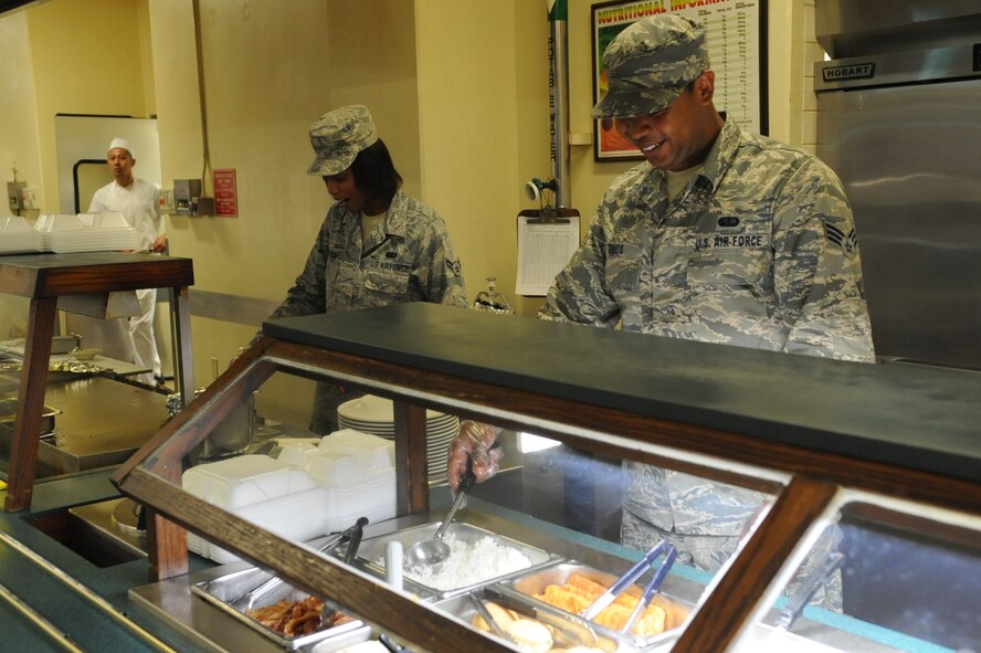U.S. Air Force Senior Airman Isiah Davis (right) and Airman 1st Class Amanda Dotson, (left) 18th Force Support Squadron food service specialists, prepare the food line for the late night shift, commonly called midnight chow, on Kadena Air Base, Japan, Aug. 19, 2014. The Marshall Dining Facility has late night hours from 10 p.m. to 12:30 a.m. every day for those that work late hours.  (U.S. Air Force photo by Airman 1st Class Zackary A. Henry)