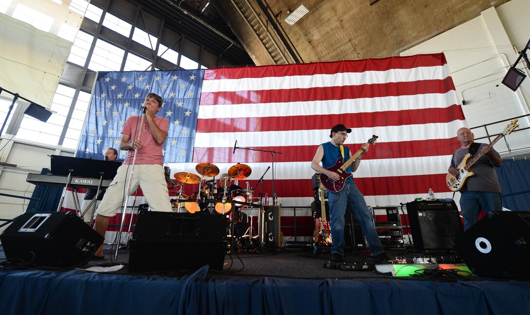 Members from the local band Dogs Without Sweaters, perform in the Pride Hangar during Ellsworth’s Black Hills Community Appreciation Day at Ellsworth Air Force Base, S.D., Aug. 16, 2014. The event was designed to thank the community for their continued support and provide them with a better understanding Ellsworth’s mission. (U.S. Air Force photo by Senior Airman Zachary Hada/Released)