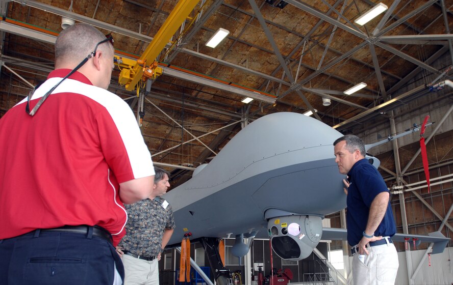 David Sprague of General Atomics gives a hangar tour to a group of civilians from the public and private sectors who visited Grand Forks Air Force Base Aug. 13, 2014, to learn more about unmanned aircraft and how they could benefit each of their respective fields. The group also heard from the 348th Reconnaissance Group, the North Dakota Air National Guard, Customs and Border Protection and Northrop Grumman. (U. S. Air Force photo/Staff Sgt. Susan L. Davis)