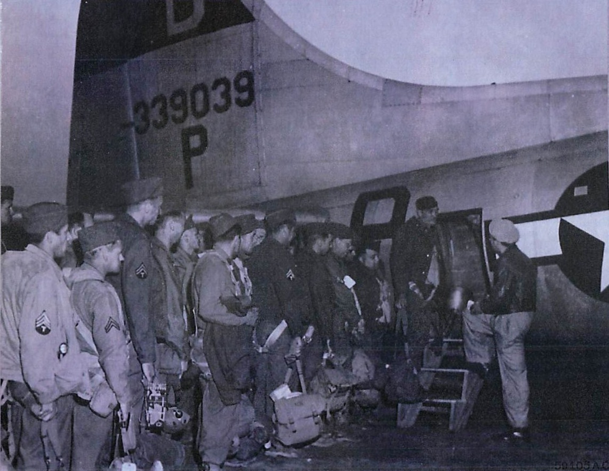 Capt. C.E. Bierman of Williamsport, Pennsylvania, checks off names of men as they enter the plane.  Pvt. Charley V. Stilner of Huntington, West Virginia, was the first man aboard. (U.S. Air Force photo)