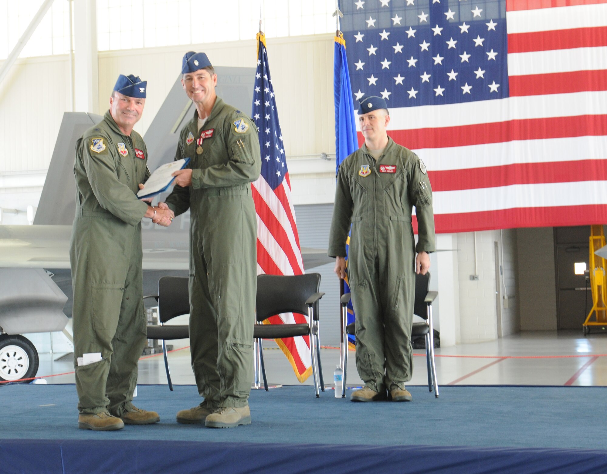 Col. William J. Butz, 192nd Operations Group commander, presents the squadron colors to Lt. Col. Micah Fesler, signifying the transfer of command of the 149th Fighter Squadron, during a change of command ceremony held July 12, 2014 at Joint Base Langley-Eustis. (U.S. Air National Guard photo by 2nd Lt. Meaghan E. M. Selki/Released)