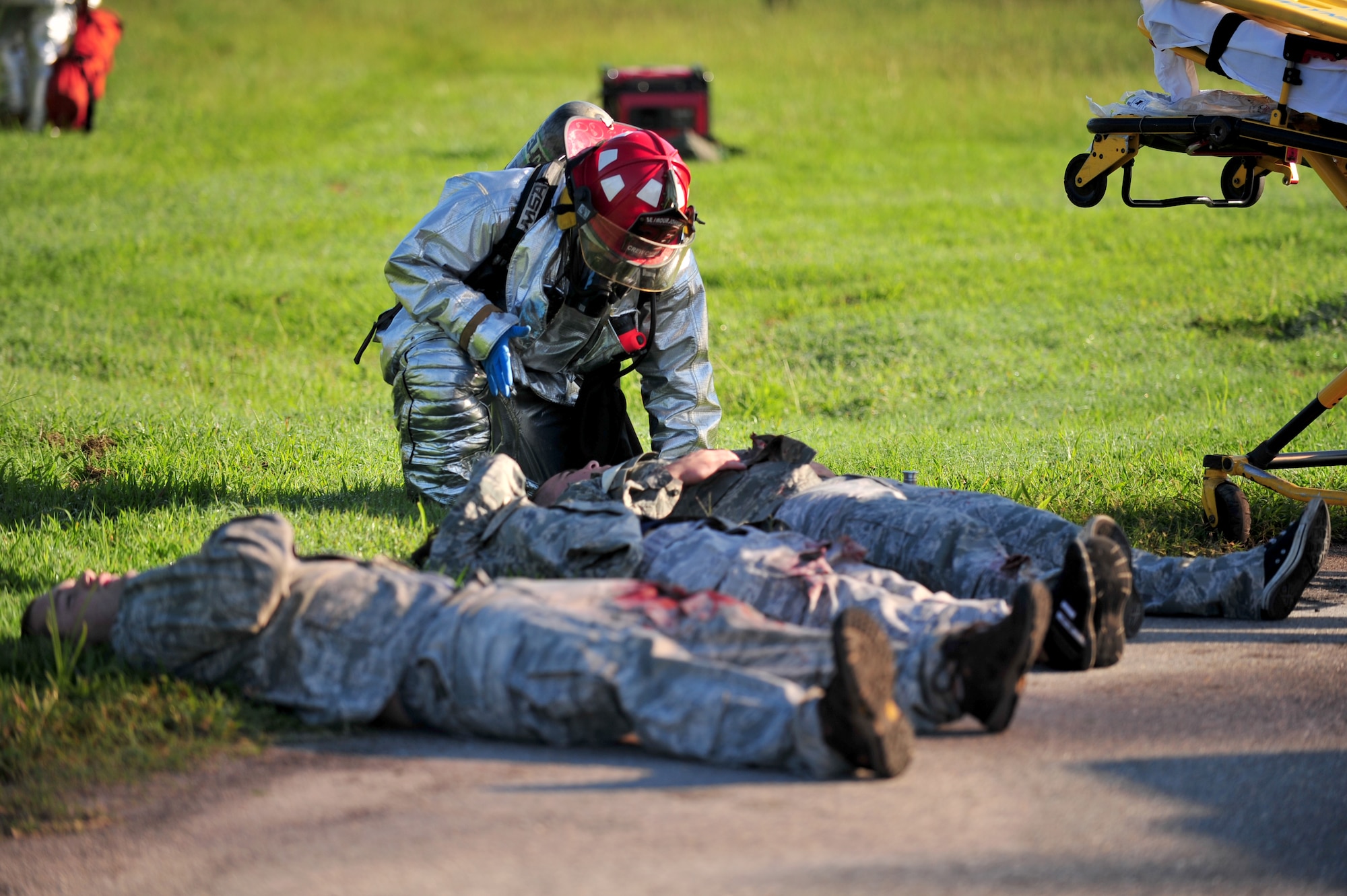 An Airman assigned to the 4th Civil Engineer Squadron fire department attends to a simulated victim of a mock KC-135R Stratotanker crash during a major accident response exercise in Goldsboro, North Carolina, Aug. 14, 2014. Seymour Johnson Air Force Base partnered with Goldsboro and Wayne County first responders for a two-day exercise designed to test the effectiveness of both the base and local authorities to a military incident in the Goldsboro area. (U.S. Air Force photo/Airman 1st Class Shawna Keyes)