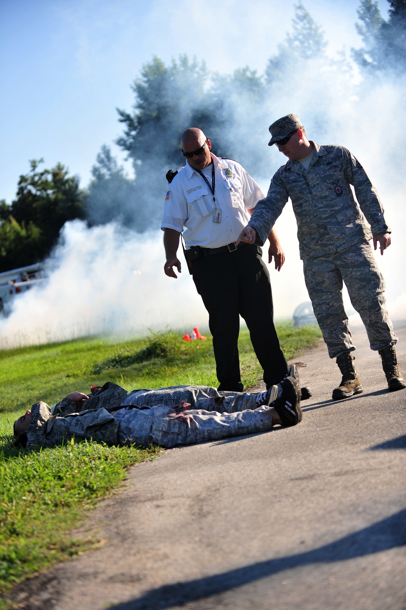 Robert Klinger (left), 4th Fighter Wing inspection team member, talks with Staff Sgt. Justin Fellure, 4th Civil Engineer Squadron firefighter, during a major accident response exercise in Goldsboro, North Carolina, Aug. 14, 2014. Seymour Johnson Air Force Base partnered with Goldsboro and Wayne County first responders for a two-day exercise designed to test the effectiveness of both the base and local authorities to a military incident in the Goldsboro area. (U.S. Air Force photo/Airman 1st Class Shawna Keyes)