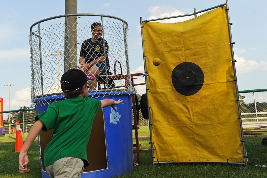 A member of Team Seymour takes aim at a dunking booth during the Summer Time Blast on Aug. 15, 2014, at Seymour Johnson Air Force Base, North Carolina. The event featured fireworks, live music, food, and family games and entertainment. (U.S. Air Force photo/Airman 1st Class Aaron J. Jenne)
