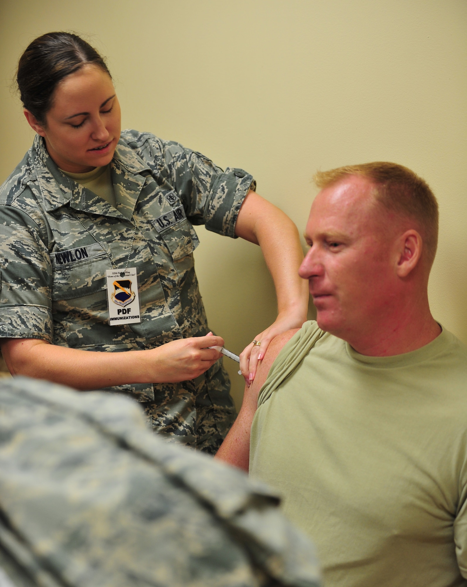 Senior Airman Noelle Newlon, 325th Medical Operations Squadron aerospace medical technician, administers a shot to Senior Master Sgt. Jeffery Whiting, 95th Aircraft Maintenance Unit assistance superintendent, during the base’s week-long deployment exercise Aug. 11. (U.S. Air Force photo by Airman 1st Class Dustin Mullen) 