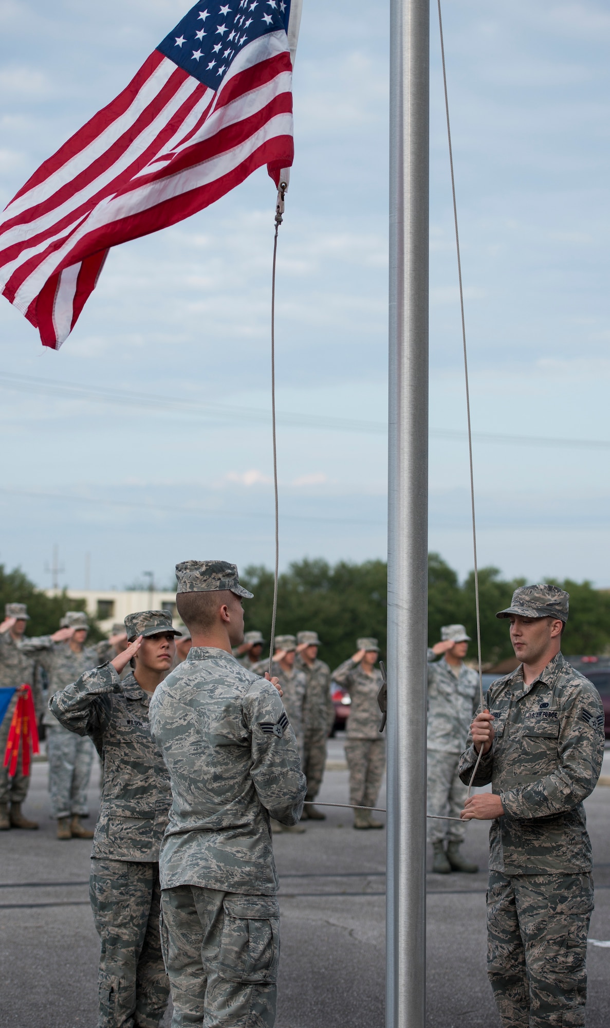 Airmen raise the American Flag during reveille at the Eglin Professional Development Center building Aug. 11.  Airman Leadership School students were in formation to salute during the ceremony.  The Airmen will graduate Aug. 26 as part of their month-long path to becoming a non-commissioned officer. Roughly every two to three weeks ALS starts up a new class, averaging seven classes a year. (U.S. Air Force photo/ Tech. Sgt. Jasmin Taylor)