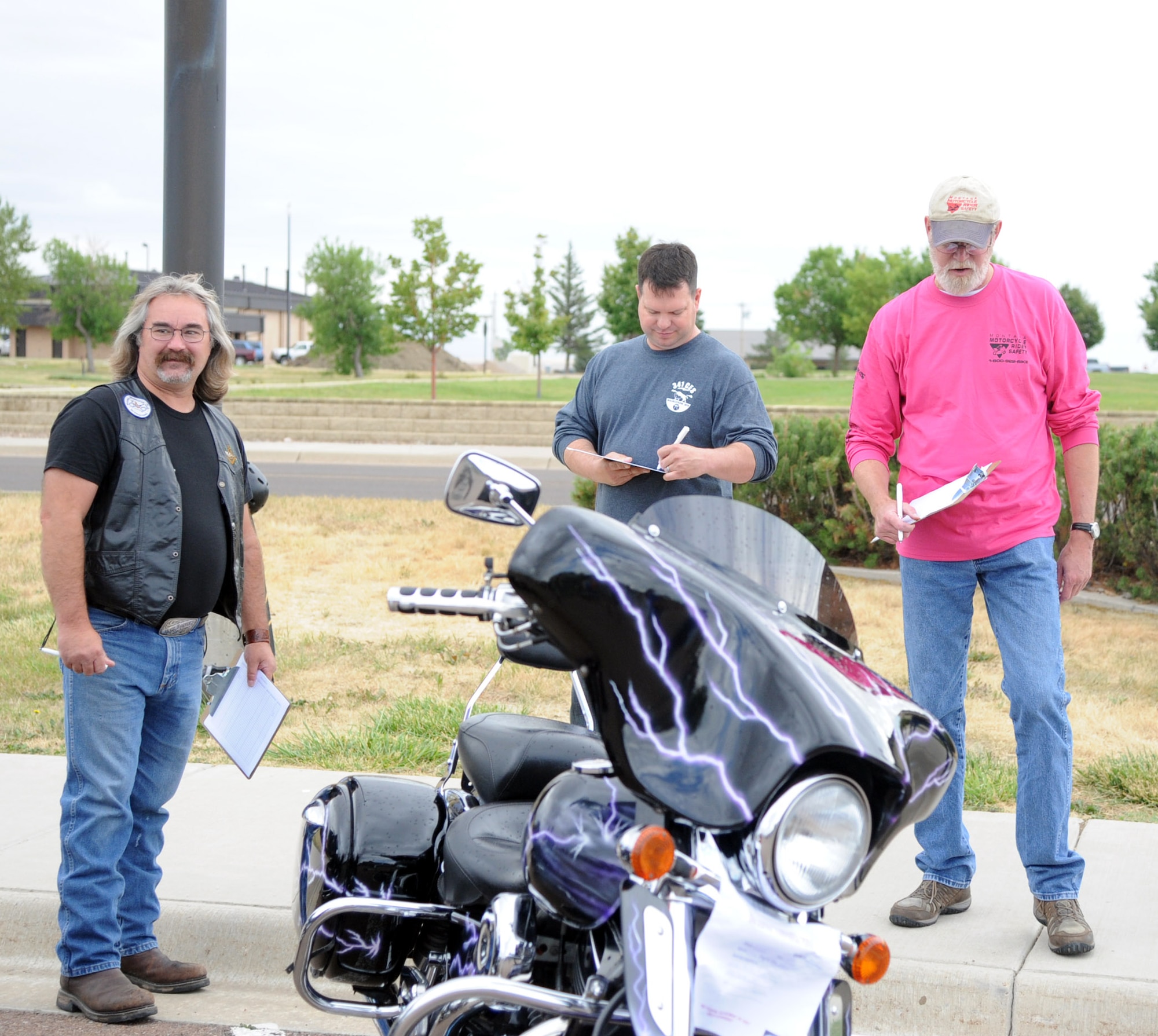 Judges look over a motorcycle during a best-looking bike competition. The competition was one of the events for the 2014 Rolling Thunder motorcycle safety event at Malmstrom Air Force Base, Mont. Aug. 14. (U.S. Air Force photo/Airman 1st Class Joshua Smoot)
