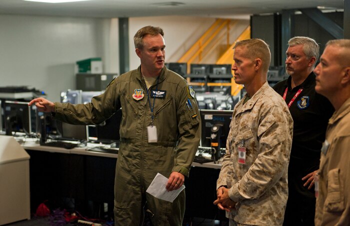 U.S. Air Force Lt. Col. Aaron Hatch (left), 505th Test Squadron director of operations, provides a briefing to U.S. Marine Corps Brig. Gen. Carl Mundy III, commanding general, 1st Marine Expeditionary Brigade, Camp Pendleton, Calif., the workings of the Combined Air Operations Center, Nellis Air Force Base, Nev., Aug. 12, 2014. The  CAOC-N is training with the 1st MEB in an integrated Large Scale Exercise 14-1. (U.S. Air Force photo by Airman 1st Class Thomas Spangler)