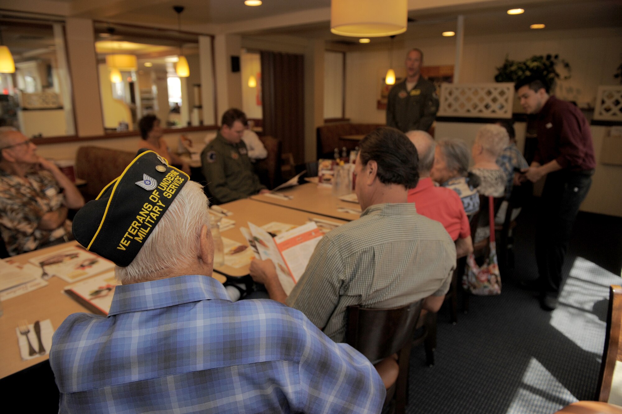 Members of the Veterans of Underage Military Service organization listen as U.S. Air Force Maj. Christopher Palmer, 357th Fighter Squadron, A-10 pilot, speaks about Davis-Monthan’s mission during a lunch in Tucson, Ariz., Aug. 13, 2014. VUMS is an organization consisting of individuals who served any branch of the United States Armed Services before they were of legal age to do so. (U.S. Air Force photo by Airman 1st Class Chris Drzazgowski/Released)