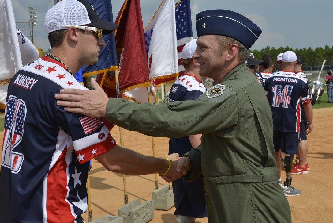 Brig. Gen. David Hicks, Air Forces Northern Vice Commander greets Wounded Warrior Amputee Softball Team player Matt Kinsey, at the opening ceremonies of the 2014 United States Specialty Sports Association Military World Softball Tournament August 14 at Frank Brown Park. The four-day event featured 92 military slow-pitch teams from U.S. military services around the world. (U.S. Photo by Master Sgt. Kurt Skoglund/Released)

