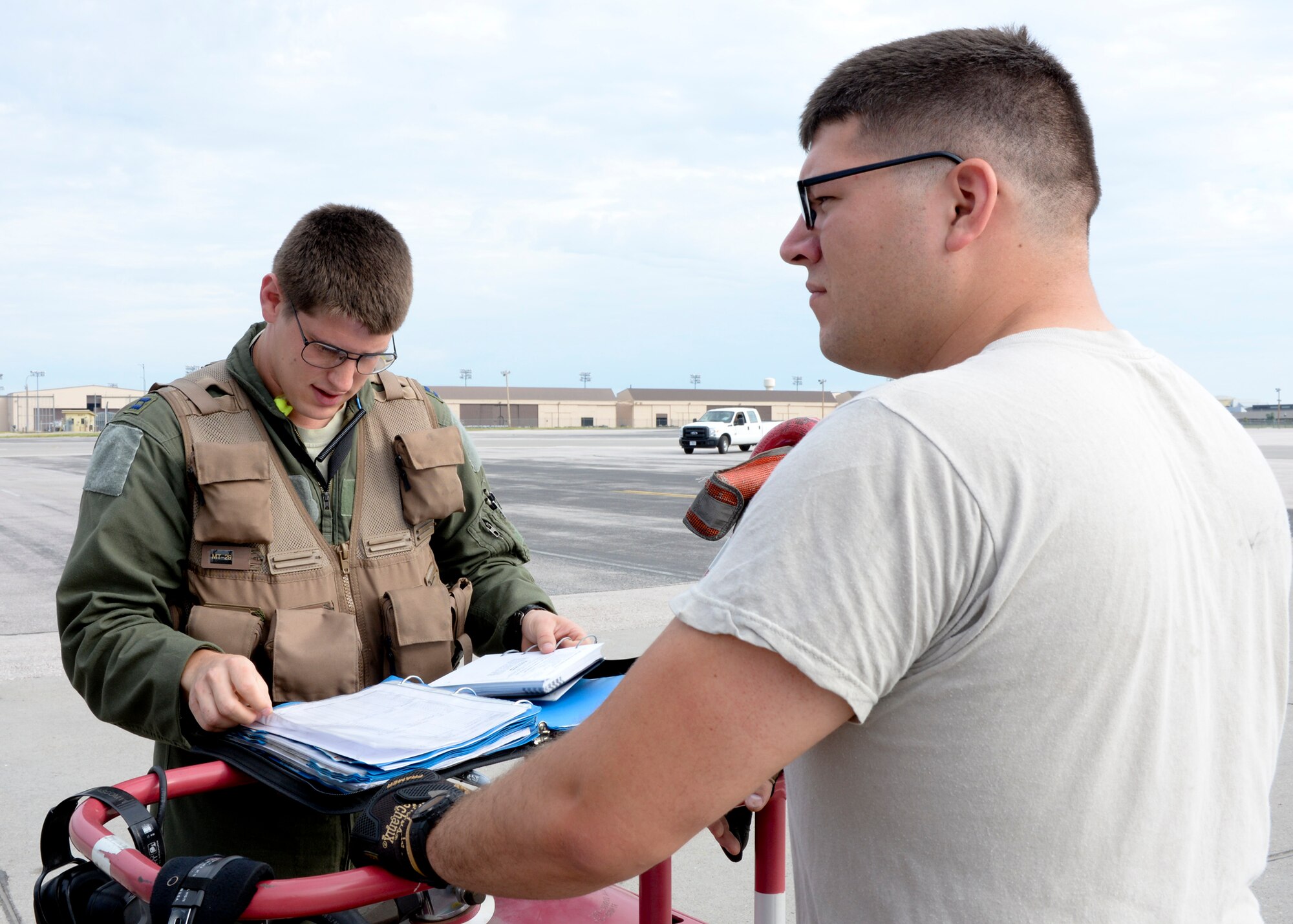 Capt. Brandon Wolf, 23rd Bomb Squadron pilot, and Senior Airman Bradley Long, 5th Aircraft Maintenance Squadron crew chief, Minot Air Force Base, N.D., review aircraft forms during a walk around inspection of a B-52 Stratofortress as part of a standoff weapons integration exercise at Ellsworth Air Force Base, S.D., Aug. 14, 2014. The standoff weapons integration training exercise was developed by B-1 and B-52 bomber crews to create an integrated mission plan involving simulated tactical scenarios to train for potential future operations. (U.S. Air Force photo by Senior Airman Anania Tekurio/Released) 