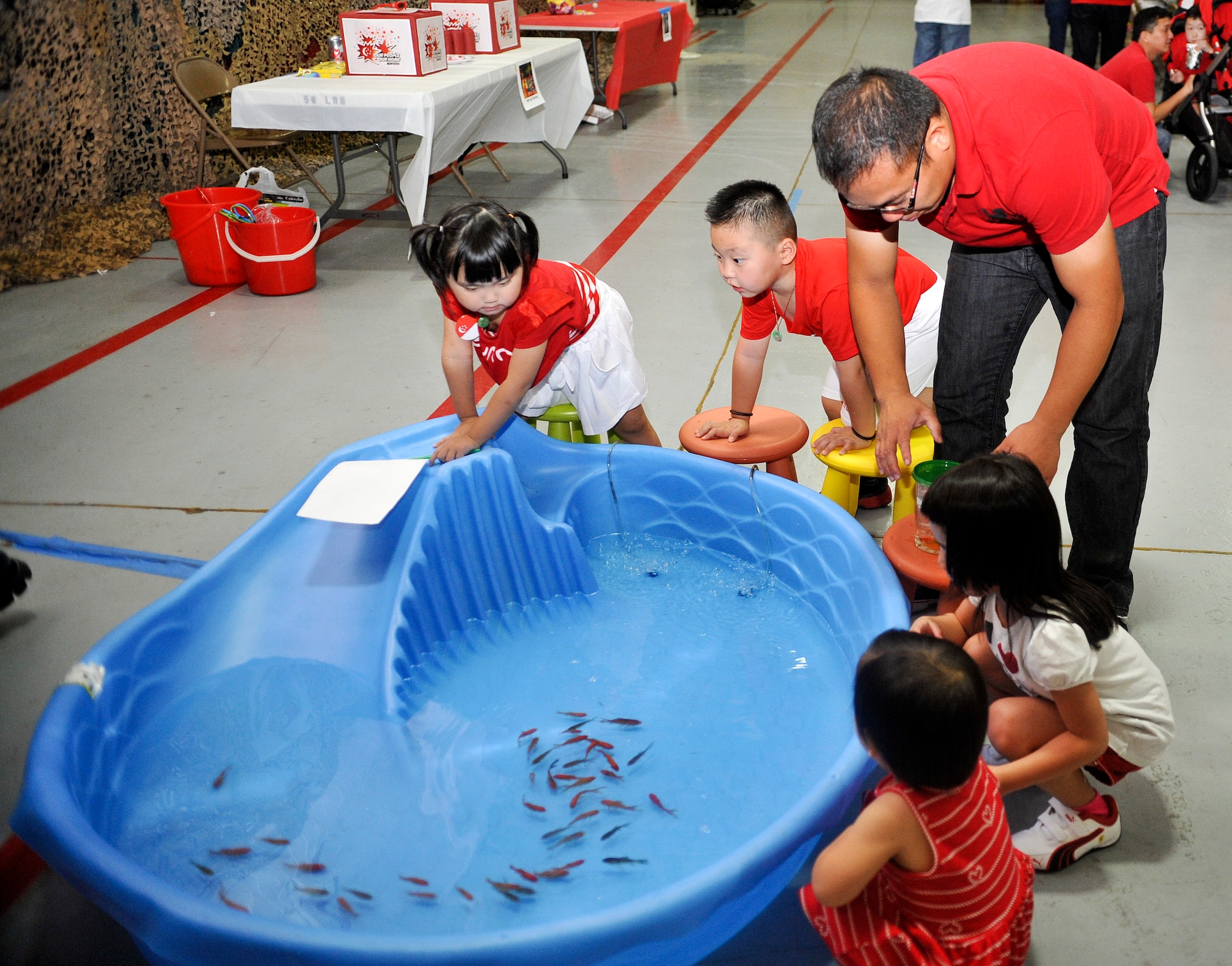 Children catch live goldfish during the celebration. (U.S. Air Force photo/Airman 1st Class Cory Gossett)