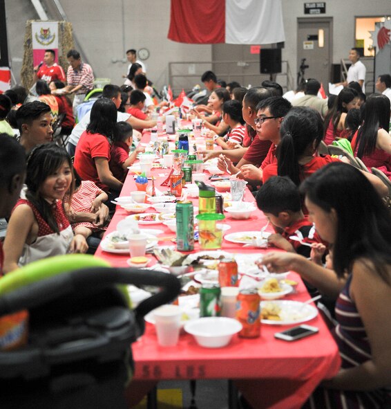 Singaporeans eat traditional food Aug. 8 during Singapore’s National Day celebration at Luke Air Force Base. Along with a feast, the celebration included games for children and a performance by the children, and videos created by members of the 425th Fighter Squadron demonstrating their pride in being Singaporeans. (U.S. Air Force photo/Airman 1st Class Cory Gossett)