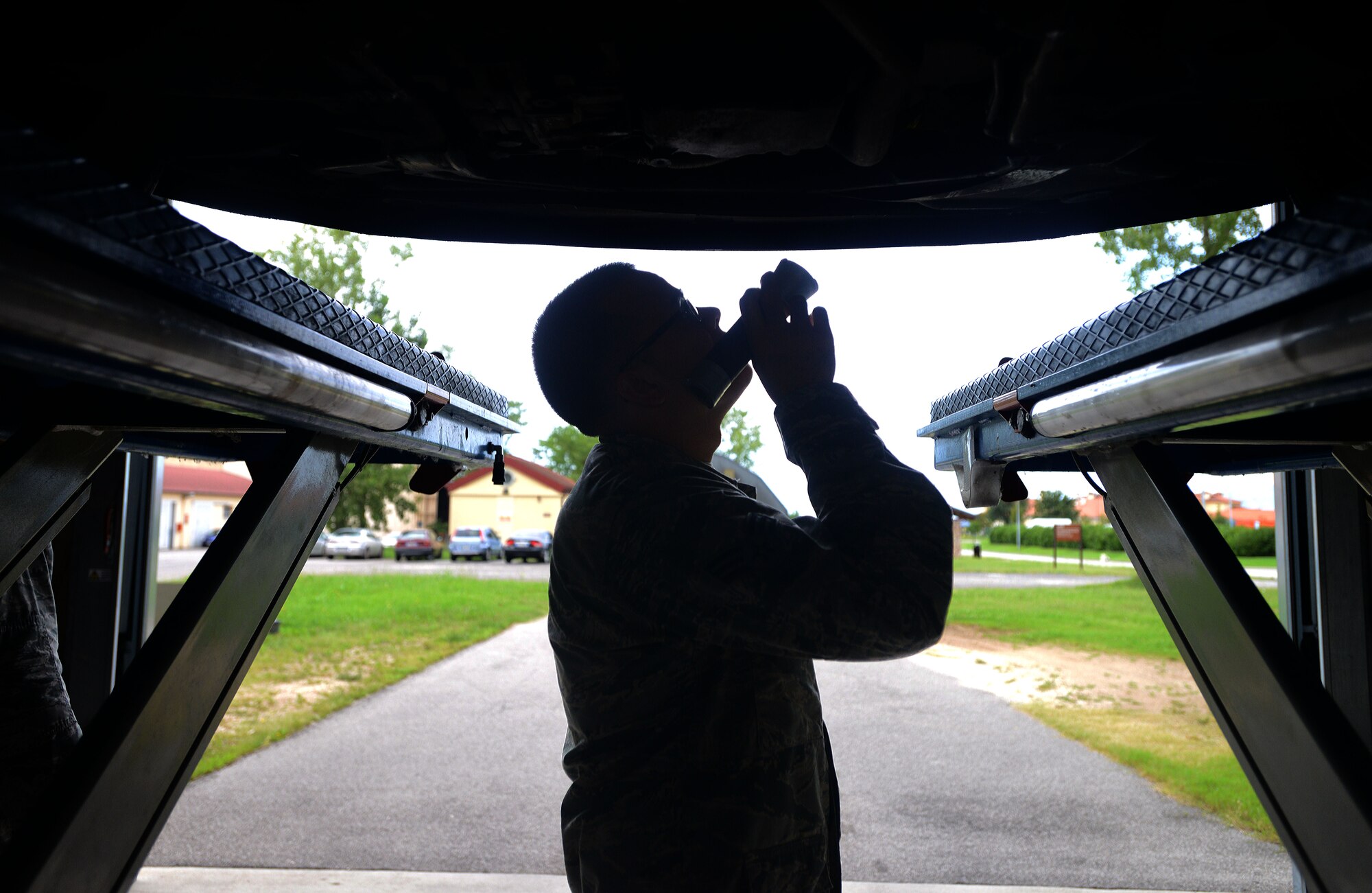 Senior Airman Adrian Torrez, 31st Logistics Readiness Squadron vehicle maintenance craftsman, inspects an engine from underneath a vehicle, Aug. 18, 2014, at Aviano Air Base, Italy. Privately owned vehicle or POV inspections, are required for all Team Aviano members looking to register a vehicle in Italy. (U.S. Air Force photo/Airman 1st Class Deana Heitzman)  