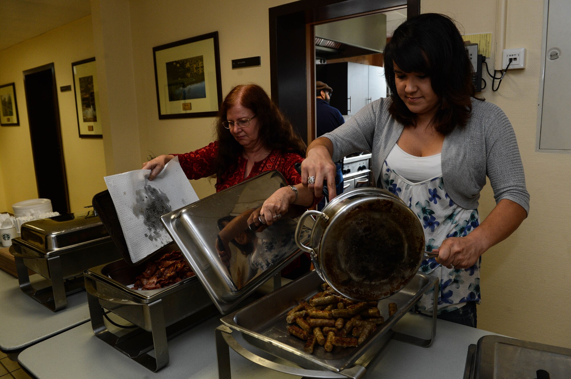 Charlotte Riter, a Geraldine, Mont., native, right, and Judy Castillo, a Phoenix native, left, serve breakfast in the chapel at Spangdahlem Air Base, Germany, Aug. 17, 2014. The Spangdahlem Catholic community hosted the breakfast for families after a religious service. The complimentary meal fed more than 80 people. The chapel provides services for a variety of religious backgrounds. (U.S. Air Force photo by Airman 1st Class Kyle Gese/Released)