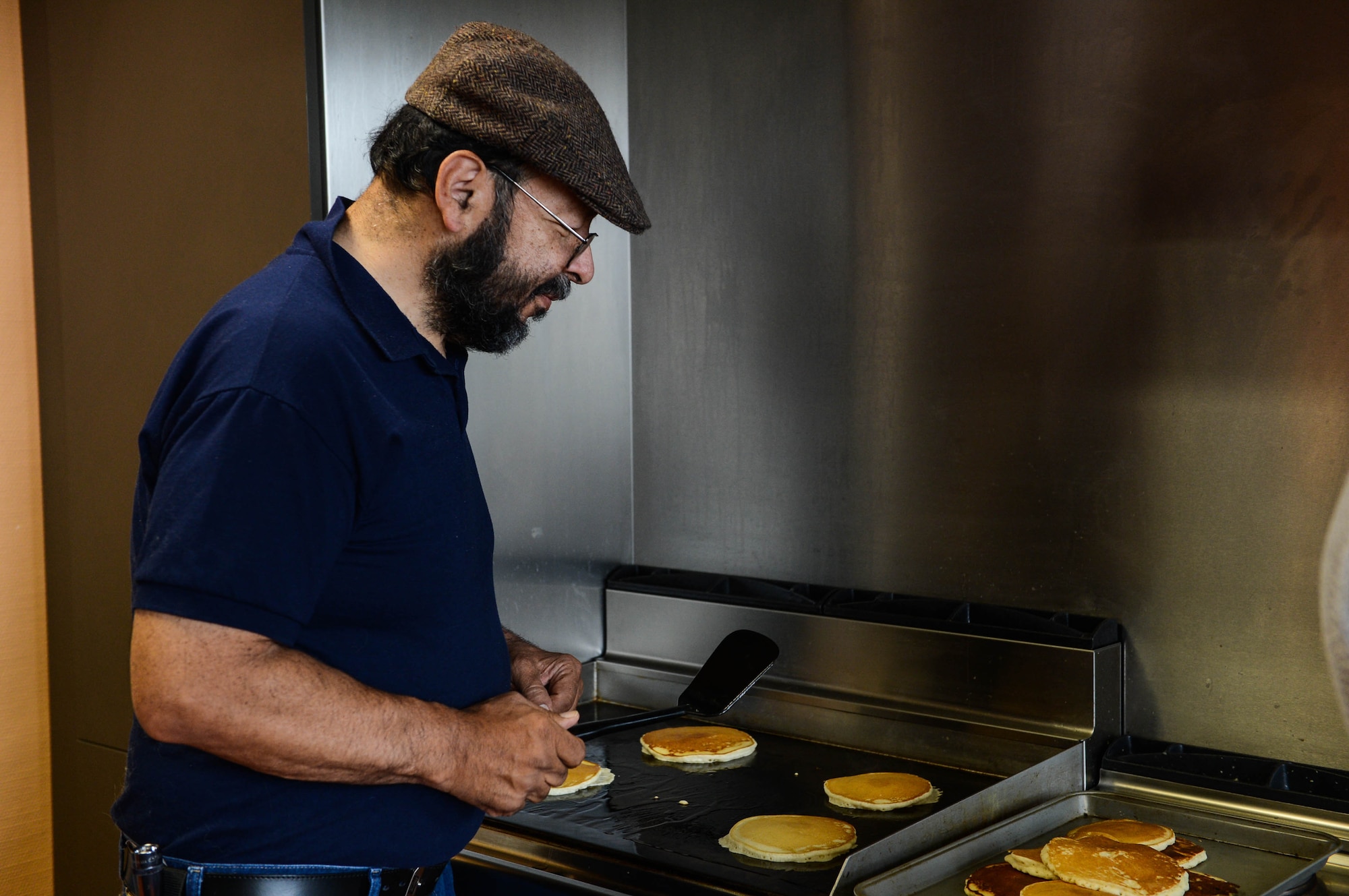 David Castillo, a chapel volunteer from Fresno, Calif., cooks for a pancake breakfast in the chapel at Spangdahlem Air Base, Germany, Aug. 17, 2014. The Spangdahlem Catholic community hosted a breakfast for families after the religious service. The complimentary meal fed more than 80 people. The chapel provides services for a variety of religious backgrounds. (U.S. Air Force photo by Airman 1st Class Kyle Gese/Released)