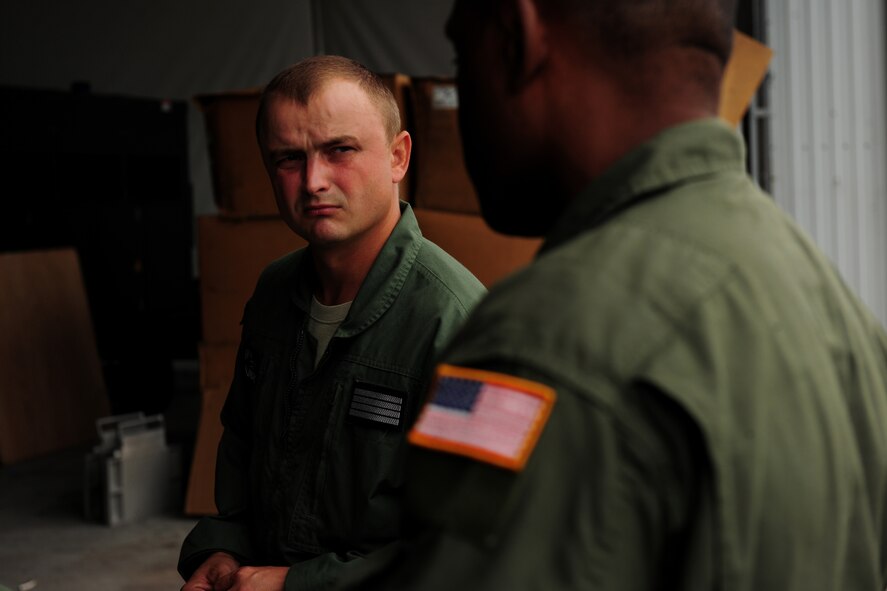 Polish Air Force Sierż (Sgt.) Zbigniew Krajniak, 33rd Transportation Air Base loadmaster, discusses mass container delivery airdrop operations with U.S. Air Force Master Sgt. Chris Minnifield, 37th Airlift Squadron loadmaster, at Powidz Air Base, Poland, Aug. 11, 2014. The discussion served as refresher training for Polish forces preparing to deliver equipment and supplies to Iraq. (U.S. Air Force photo by Staff Sgt. Jarad A. Denton/Released)