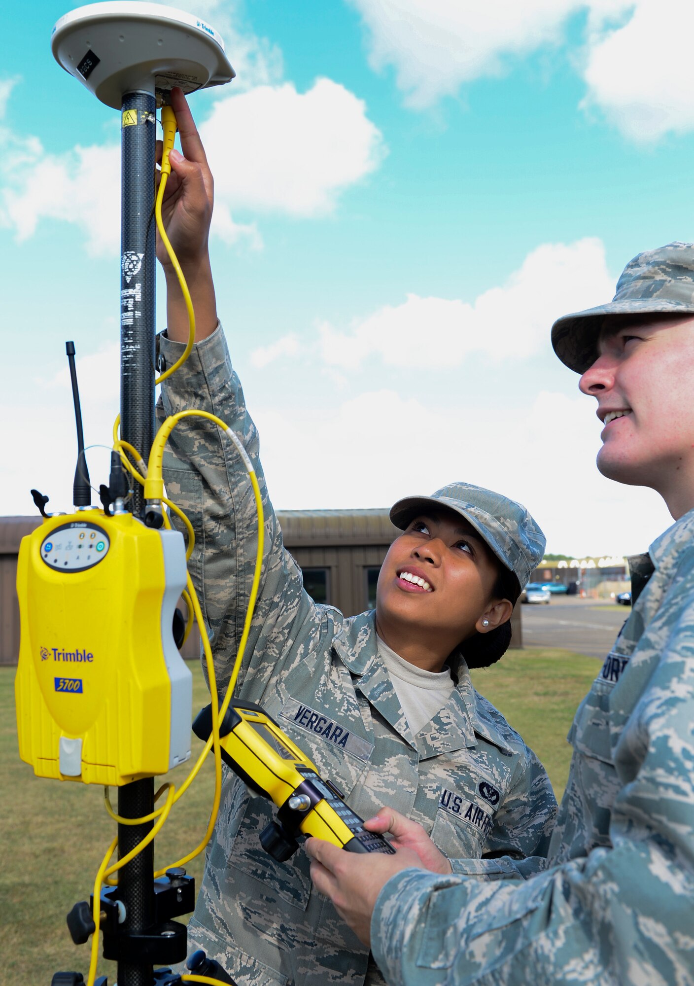 Senior Airman Hollykris Vergara, 48th Civil Engineer Squadron engineering journeyman, explains to Airman 1st Class Timothy Callahan, 48th CE engineering apprentice, how to configure land survey equipment with the proper antenna at Royal Air Force Lakenheath, England, Aug. 11, 2014. Vergara was nominated for a Liberty Spotlight because she displays the core value of Service Before Self. (U.S. Air Force photo by Airman 1st Class Dawn M. Weber/Released)