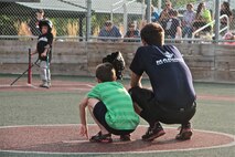 Kristopher Hennings, a Poolee with Recruiting Substation North Lansing, Recruiting Station Lansing, crouches next to a player in the Miracle League of Mid-Michigan during the opening games of the fall season Aug. 18, 2014 in Lansing, Mich. Marines and poolees of RS Lansing were invited to attend the opening games of the fall season to help out as "buddies". The league gives children with physical and mental disabilities the opportunity to play baseball through the use of a specialized rubber field and equipment. The buddies are volunteers from around the community that assist the players in hitting, throwing, catching, and running the bases.  