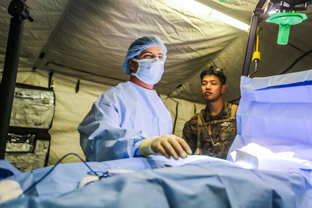 A corpsman with 1st Medical Battalion, 1st Marine Expeditionary Brigade, prepares to perform surgery on a mock casualty as part of a simulated casualty evacuation at Marine Corps Air Ground Combat Center Twentynine Palms, Calif., Aug. 6, 2014. The casualty evacuation was part of Large Scale Exercise 2014, being conducted from Aug. 8-14. LSE-14 is a bilateral training exercise between the U.S. and Canada which includes live, simulated, and constructive operations to enhance both countries’ ability to activate and deploy a Marine Air Ground Task Force with speed and effectiveness in support of the full range of military operations as required by combatant commanders. (U.S. Marine Corps photo by Lance Cpl. Caitlin Bevel)