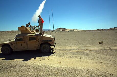 A Marine with Combat Logistics Battalion 5, follows the standard operation procedure to warn an incoming truck to not proceed any closer, during exercise Backlog aboard Marine Air Ground Combat Center, Twentynine Palms, Calif., August 7, 2014. This exercise was the cumulating event of a 30-day integrated training exercise in which Marines were instructed in multiple types of convoys and standard operating procedures for unfamiliar scenarios. (Official Marine Corps Photo by Lance Corporal Ashton Buckingham)