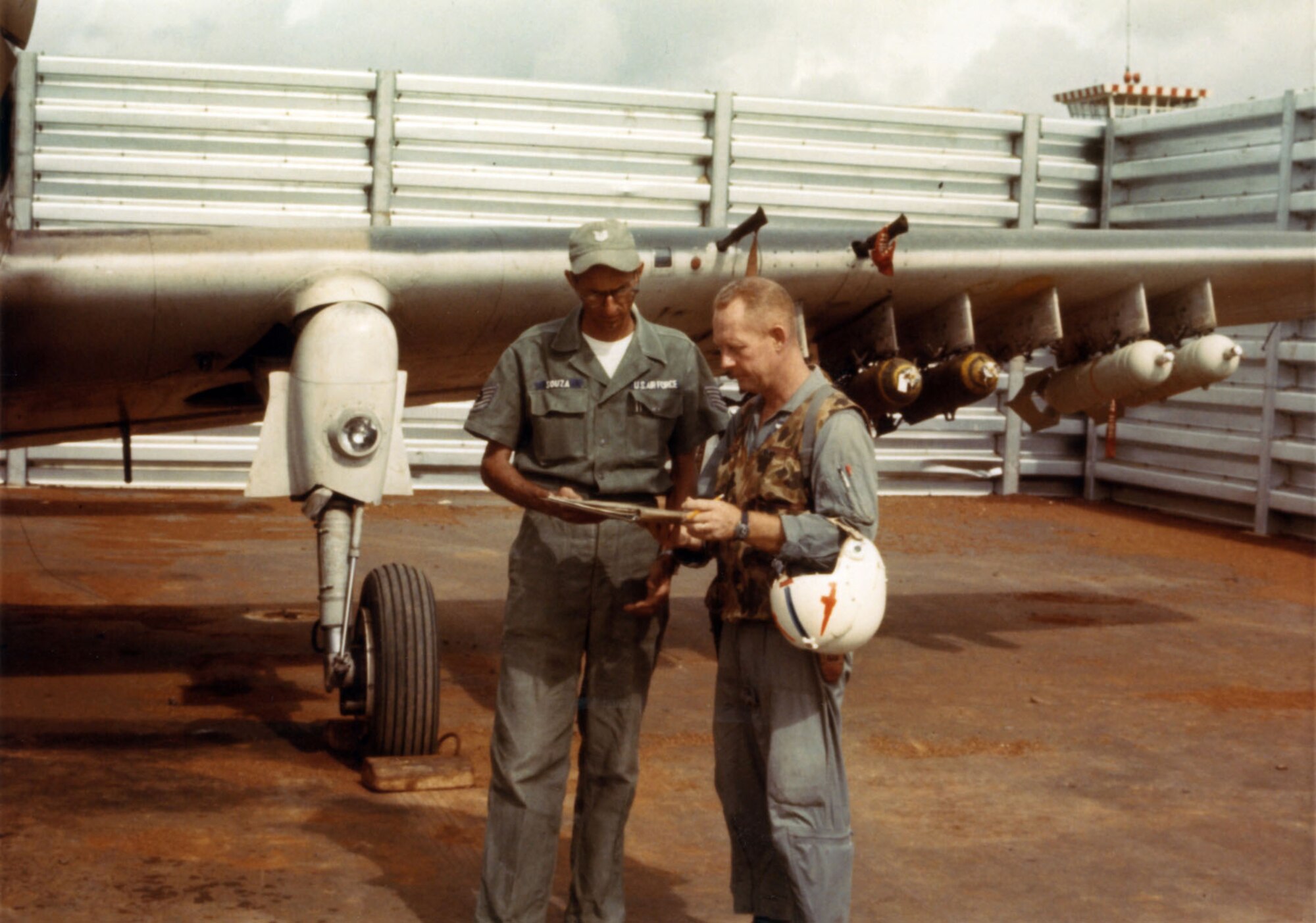 Maj. Bernard Fisher, right, looks over aircraft forms with crew chief Tech Sgt. L.J. Souza, 1966, at Pleiku Air Base, South Vietnam. Air Force Medal of Honor recipient retired Col. Bernard Fisher passed away Aug. 16, 2014. (U.S. Air Force photo)