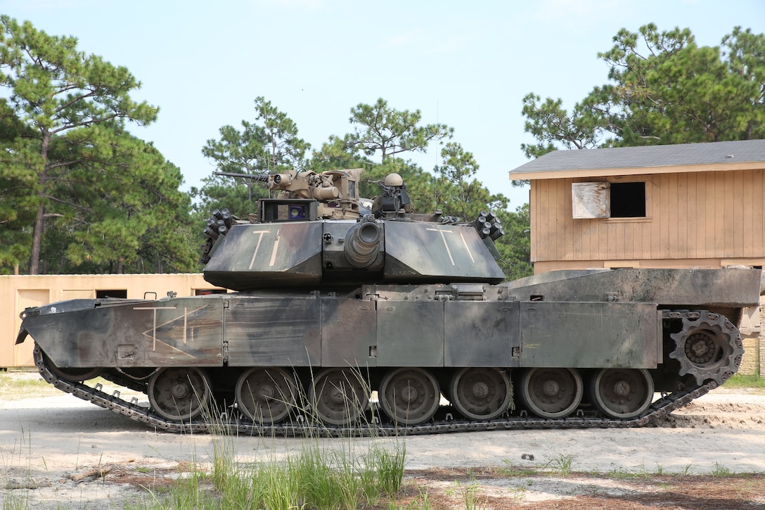An M1A1 Abrams tank with 4th Tank Battalion takes a defensive position while conducting an assault on a simulated enemy town Aug. 17, 2014 aboard Camp Lejeune, N.C., during exercise Heavy Metal 14. The tanks maneuvered with infantry units to capture key locations throughout the city.