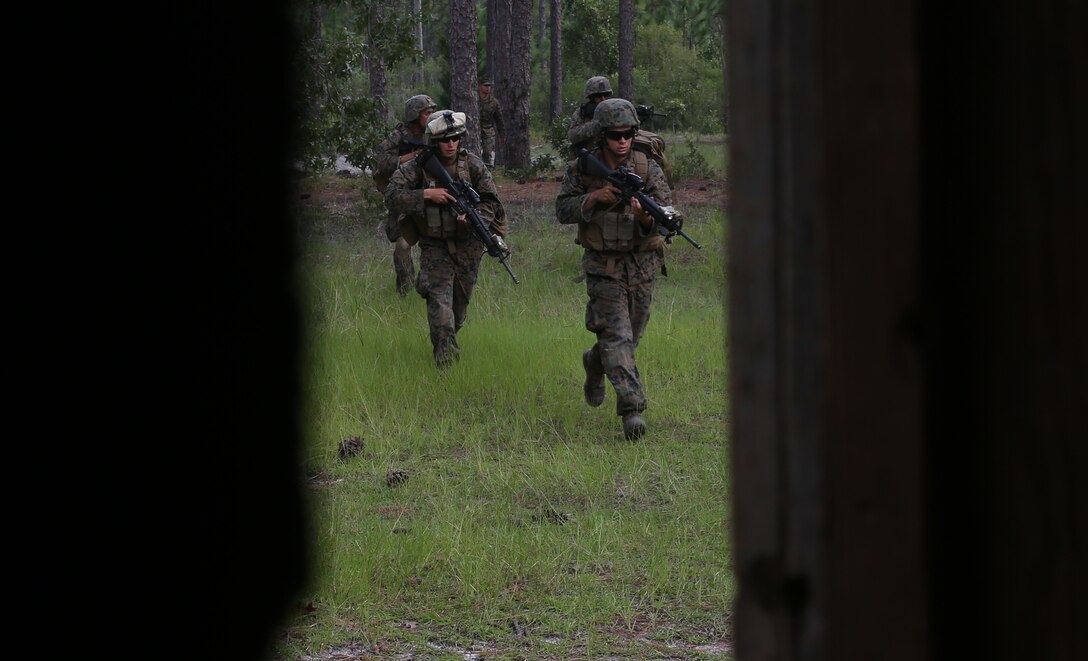 Marines with 1st Battalion, 24th Marine Regiment, patrol near the tree line while conducting an assault on a simulated enemy town Aug. 17, 2014, aboard Camp Lejeune, N.C., during exercise Heavy Metal 14.  During the assault, infantry units moved from house-to-house clearing them of all enemy forces.  