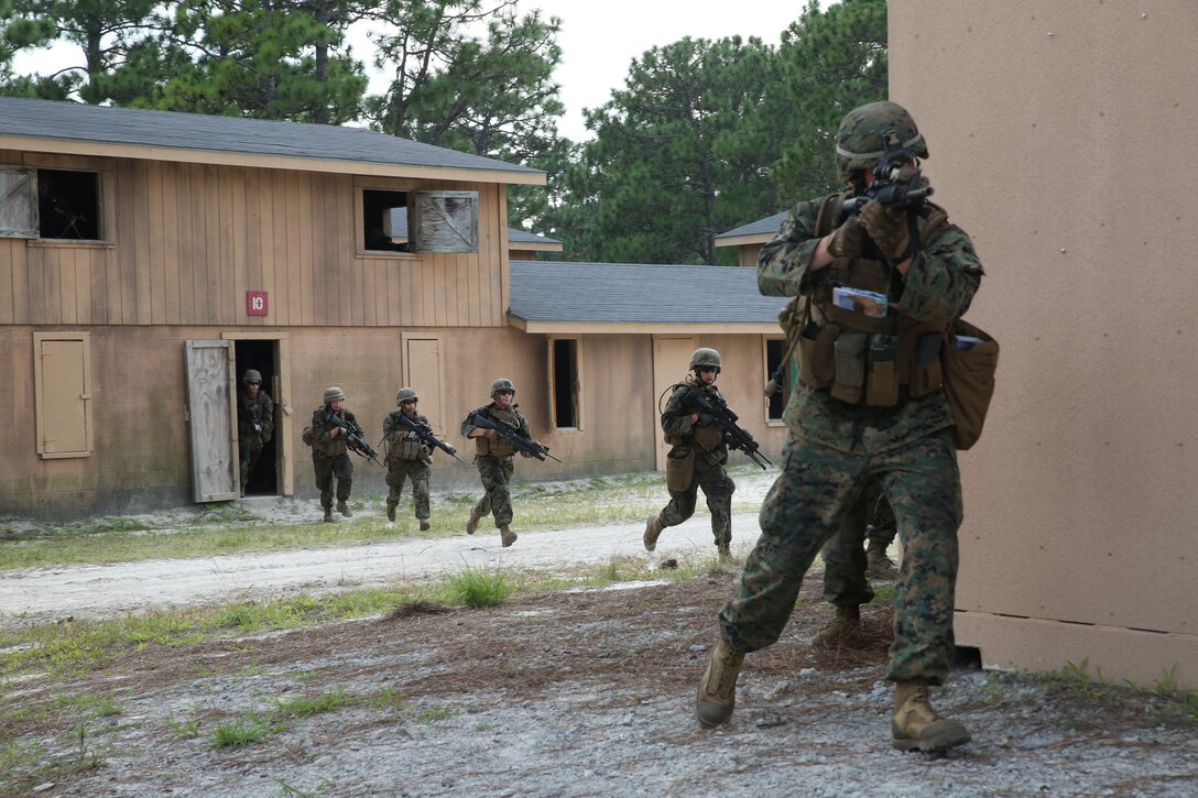 Marines with 1st Battalion, 24th Marine Regiment, conduct an assault on a simulated enemy town Aug. 17, 2014, aboard Camp Lejeune, N.C., during exercise Heavy Metal 14. During the assault, infantrymen moved from house-to-house, clearing them of all simulated enemy forces. Simultaneously, tanks and armored vehicles moved alongside them through the streets during the combined arms attack