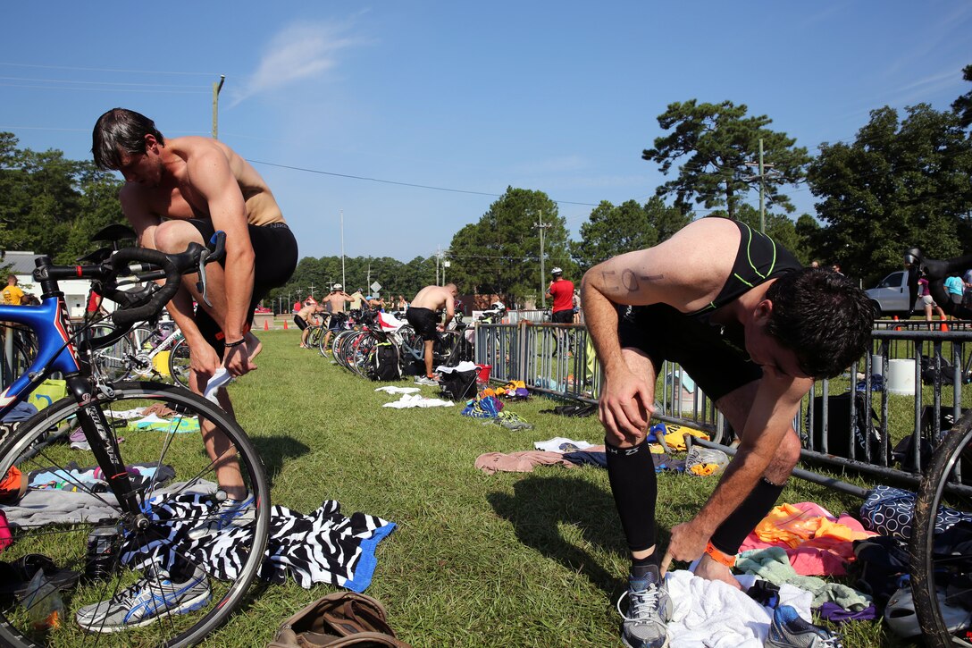 Matt Dougherty, left, and Sam Whitt prepare for a 10-mile bike ride after finishing the 400-meter swim portion of Marine Corps Community Services' Sprint Triathlon/Relay at Marine Corps Air Station Cherry Point, N.C., Aug. 16, 2014. Dougherty, a native of Ayden, N.C., placed first in the 18–24 age group; and Whitt, a native of Raleigh, N.C., is a local attorney who took on the competition with his daughter as a "bucket list idea."  