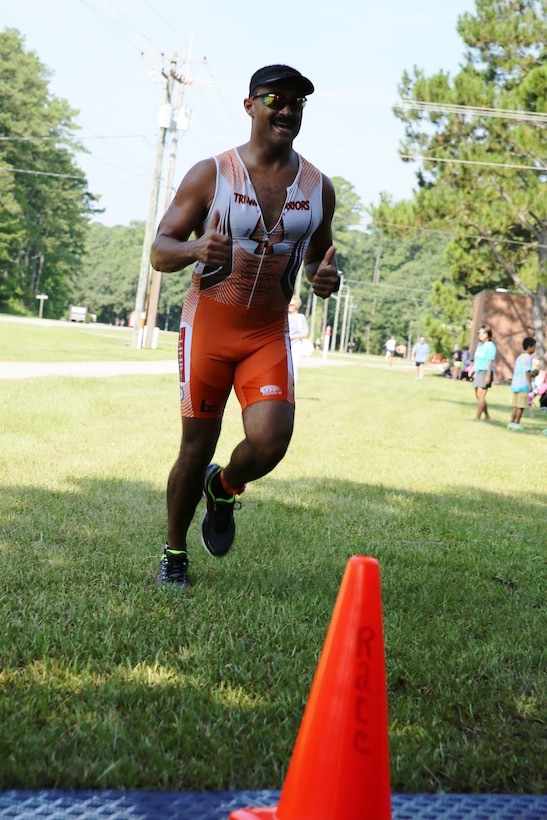 Mark Lockler gives a thumbs up before crossing the finish line of Marine Corps Community Services' Sprint Triathlon/Relay at Marine Corps Air Station Cherry Point, N.C., Aug. 16, 2014. Lockler finished first in the 40–44 age group. Lockler is a local attorney and native of Lumberton, N.C.