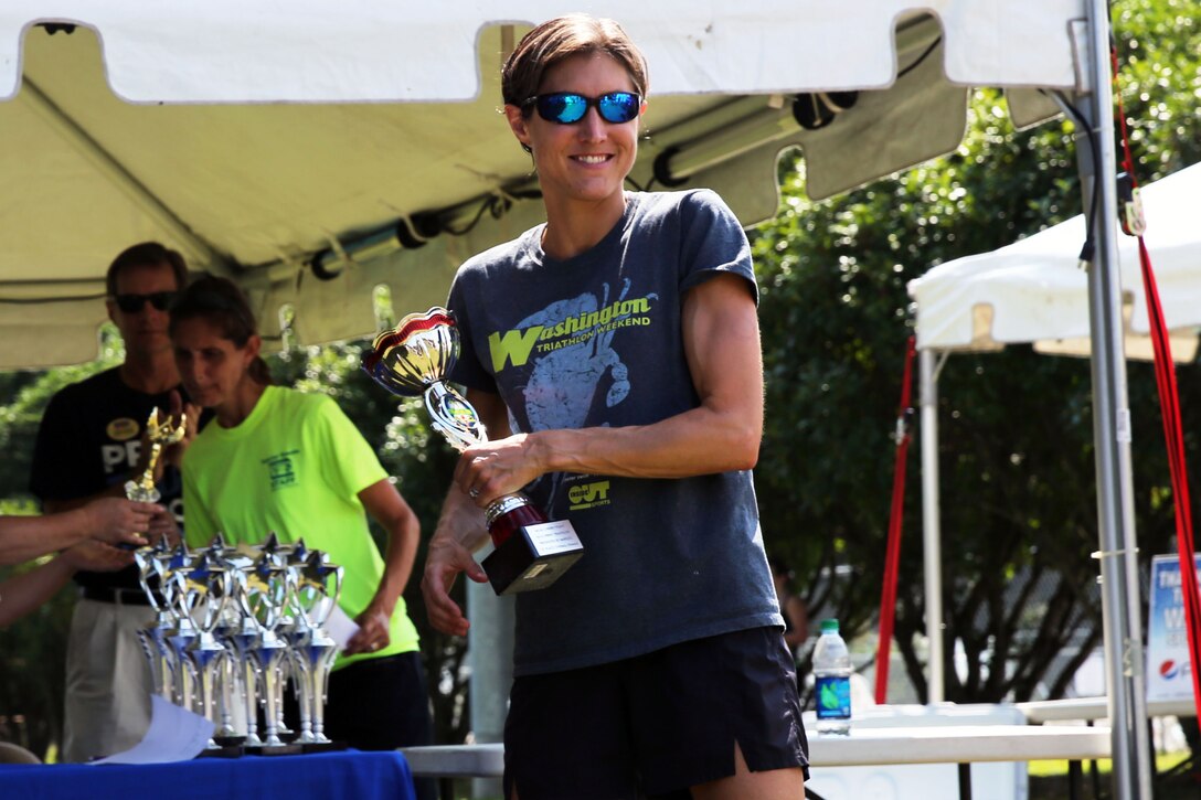 Andrea Packard claims the female first place trophy after finishing Marine Corps Community Services' Sprint Triathlon/Relay at Marine Corps Air Station Cherry Point, N.C., Aug. 16, 2014. Packard is a local business owner in New Bern, N.C., and has been running triathlons for six years. 