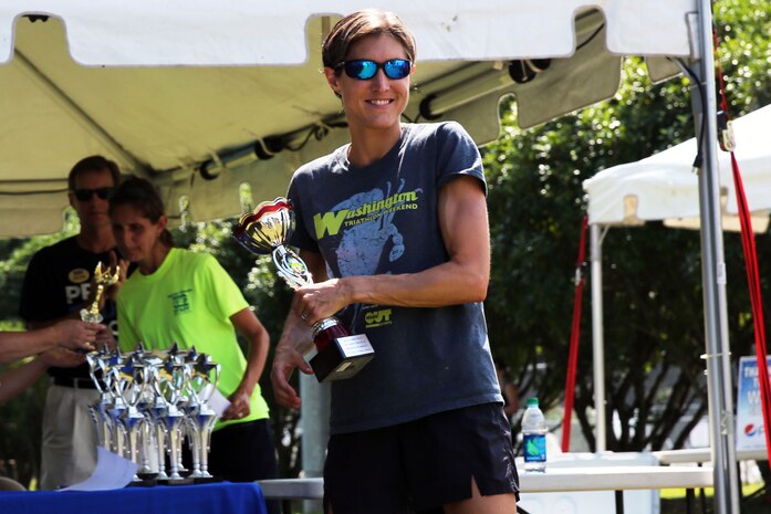 Andrea Packard claims the female first place trophy after finishing Marine Corps Community Services' Sprint Triathlon/Relay at Marine Corps Air Station Cherry Point, N.C., Aug. 16, 2014. Packard is a local business owner in New Bern, N.C., and has been running triathlons for six years. 