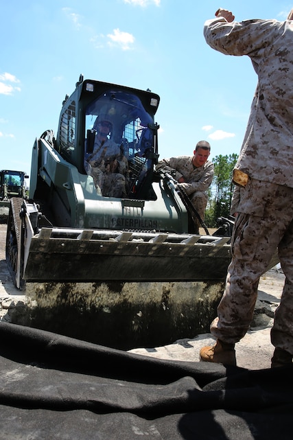 Combat engineers with Marine Wing Support Squadron 271 fill a simulated crater during a Base Recovery After Attack drill at Marine Corps Outlying Field Camp Davis, N.C., Aug. 14, 2014. A BRAAT drill simulates an enemy attack on a base and provides steps to return runways, facilities and essential services to operational conditions.
