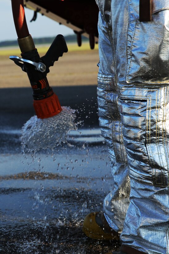 Lance Cpl. Ryan Staats holds a fire hose during Aircraft Rescue and Firefighting  training at Marine Corps Air Station Cherry Point, N.C., Aug. 14, 2014. The Marines simulated aircraft fires to prepare themselves for the conditions, procedures and stressors of an aircraft flight line fire. Staats is an ARFF specialist with Headquarters and Headquarters Squadron, and is a native of Fort Myers, Fla.