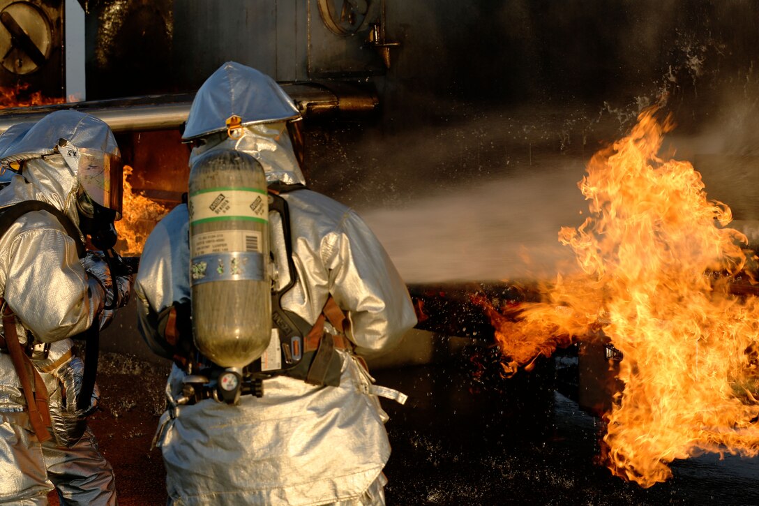 Cpl. Kyle James, left, and Sgt. Ruben Ochoa attempt to extinguish an aircraft fire during Aircraft Rescue and Firefighting training at Marine Corps Air Station Cherry Point, N.C., Aug. 14, 2014. James and Ochoa are both ARFF specialists with Headquarters and Headquarters Squadron. James is a native of Pasadena, Texas, and Ochoa is a native of Bakersfield, Calif.