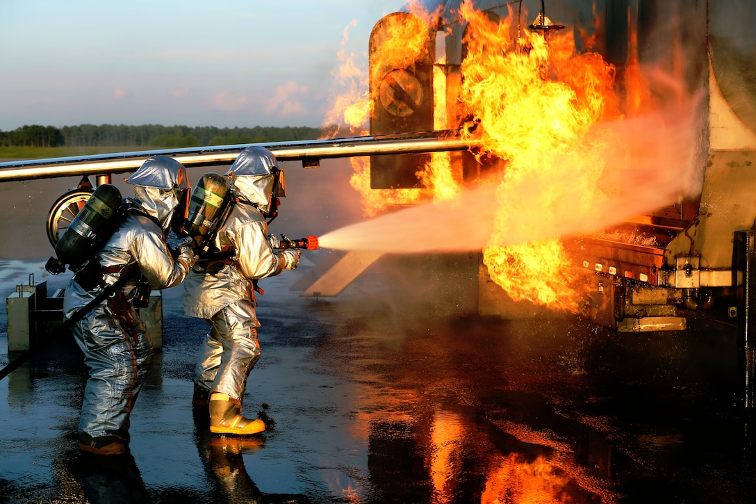 Cpl. Kyle James, left, and Sgt. Ruben Ochoa battle an aircraft fire during Aircraft Rescue and Firefighting training at Marine Corps Air Station Cherry Point, N.C., Aug. 14, 2014. James and Ochoa are both ARFF specialists with Headquarters and Headquarters Squadron. James is a native of Pasadena, Texas, and Ochoa is a native of Bakersfield, Calif.