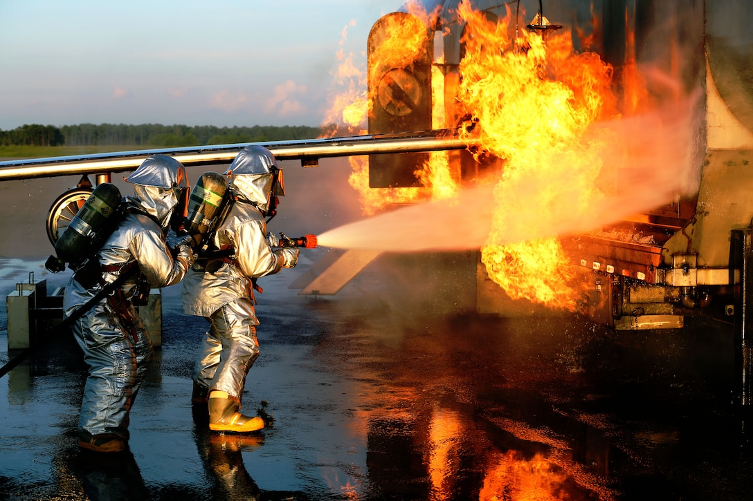 Cpl. Kyle James, left, and Sgt. Ruben Ochoa battle an aircraft fire during Aircraft Rescue and Firefighting training at Marine Corps Air Station Cherry Point, N.C., Aug. 14, 2014. James and Ochoa are both ARFF specialists with Headquarters and Headquarters Squadron. James is a native of Pasadena, Texas, and Ochoa is a native of Bakersfield, Calif.